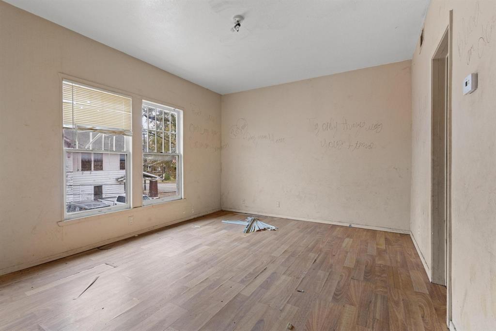 646 South Main Street Paris, TX 75460 - Photo 9 of 39 a view of an empty room with wooden floor and a window