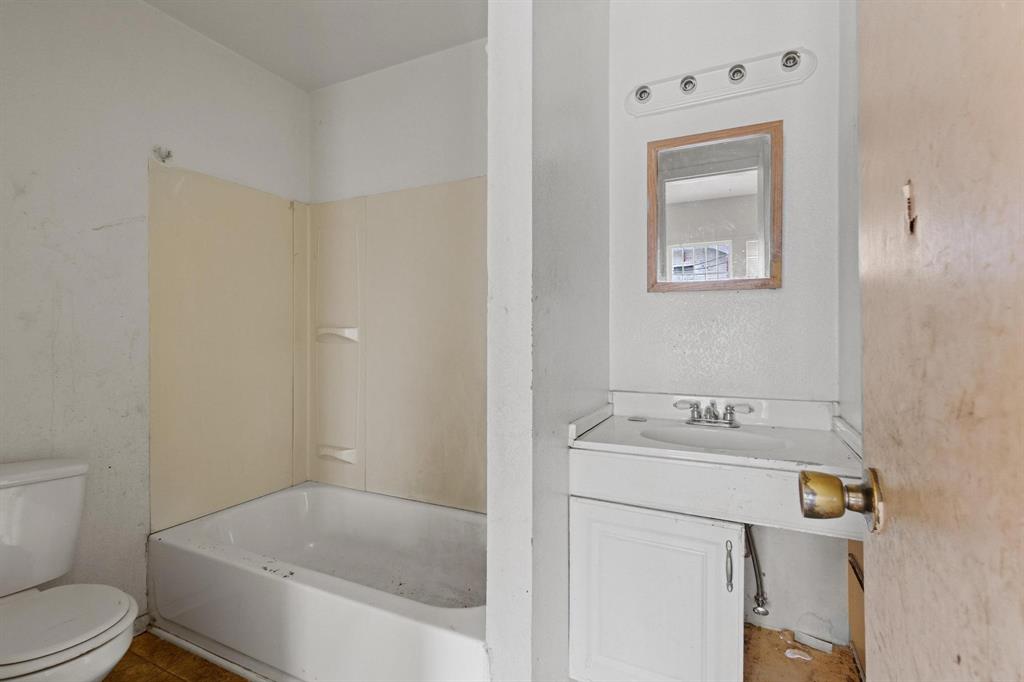 646 South Main Street Paris, TX 75460 - Photo 10 of 39 a bathroom with a sink mirror vanity and toilet