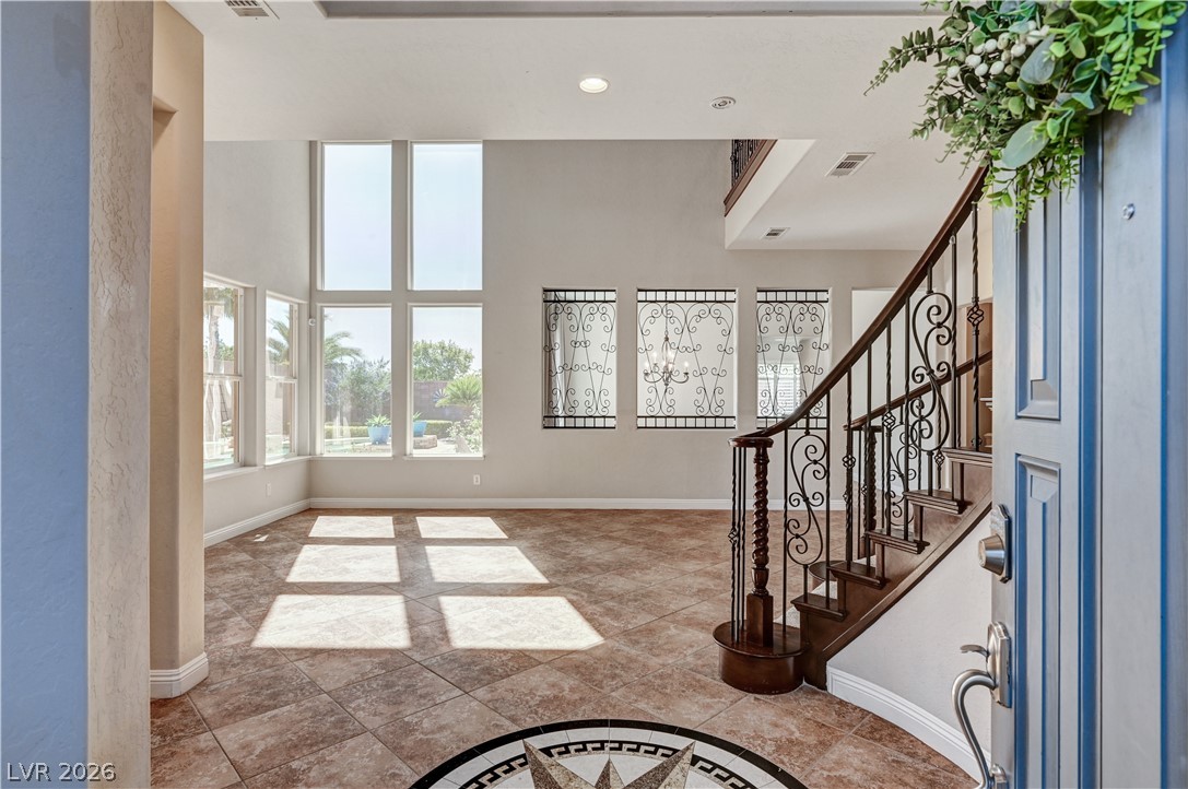 2793 Rosenhearty Drive Henderson, NV 89044 - Photo 5 of 77 A grand entrance welcomes you with a decorative compass medallion, dual-height windows, and a sweeping wrought iron staircase.