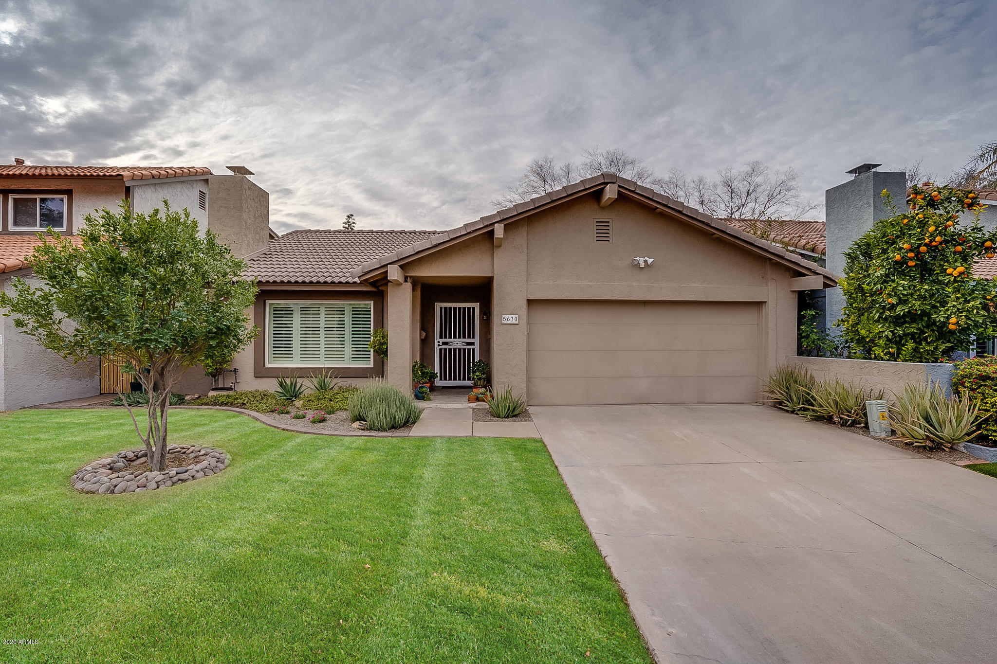 5630 South Outrigger Road Tempe, AZ 85283 - Photo 1 of 38 a front view of a house with a yard and garage