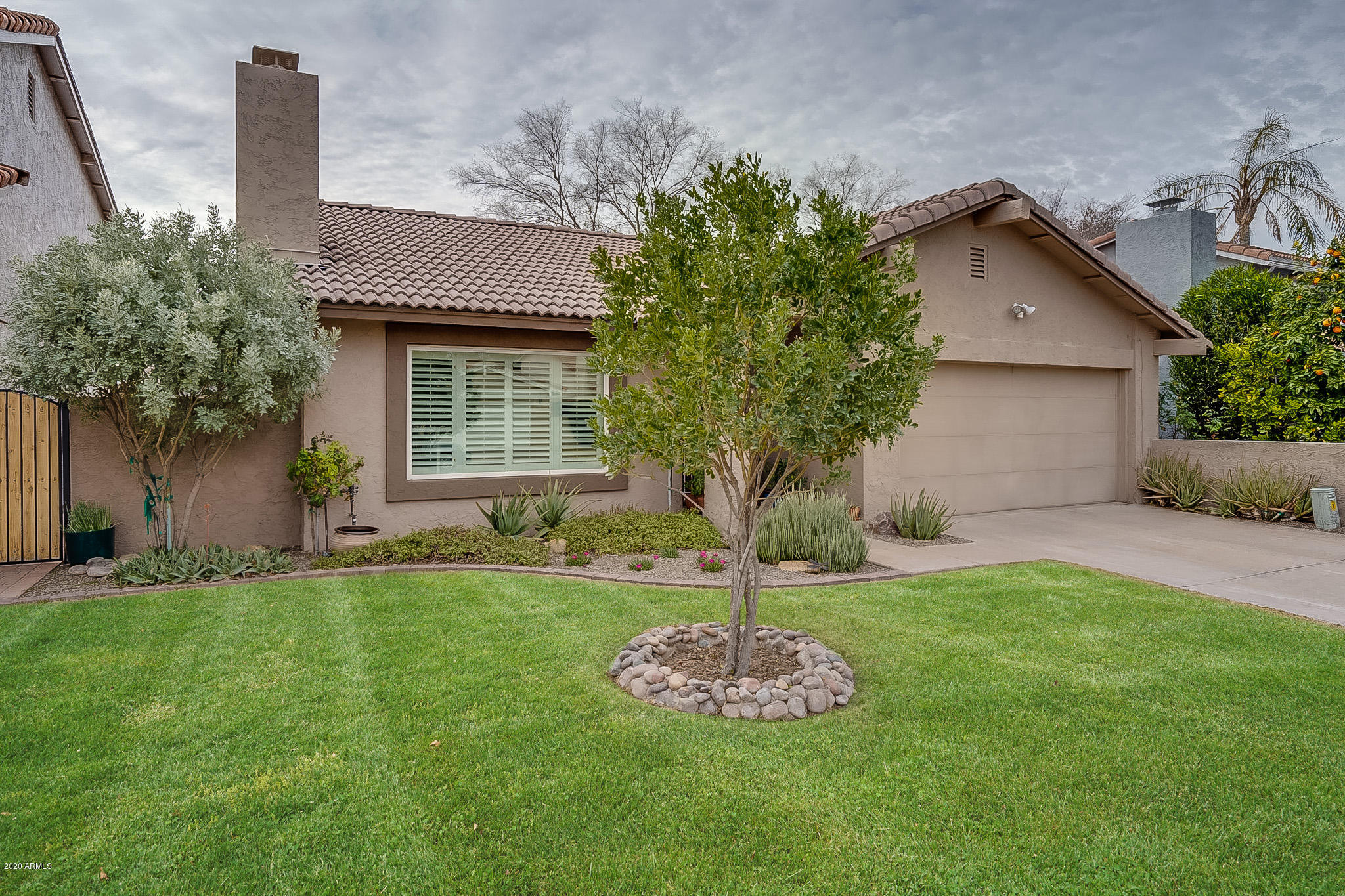 5630 South Outrigger Road Tempe, AZ 85283 - Photo 6 of 38 a front view of a house with a garden and yard