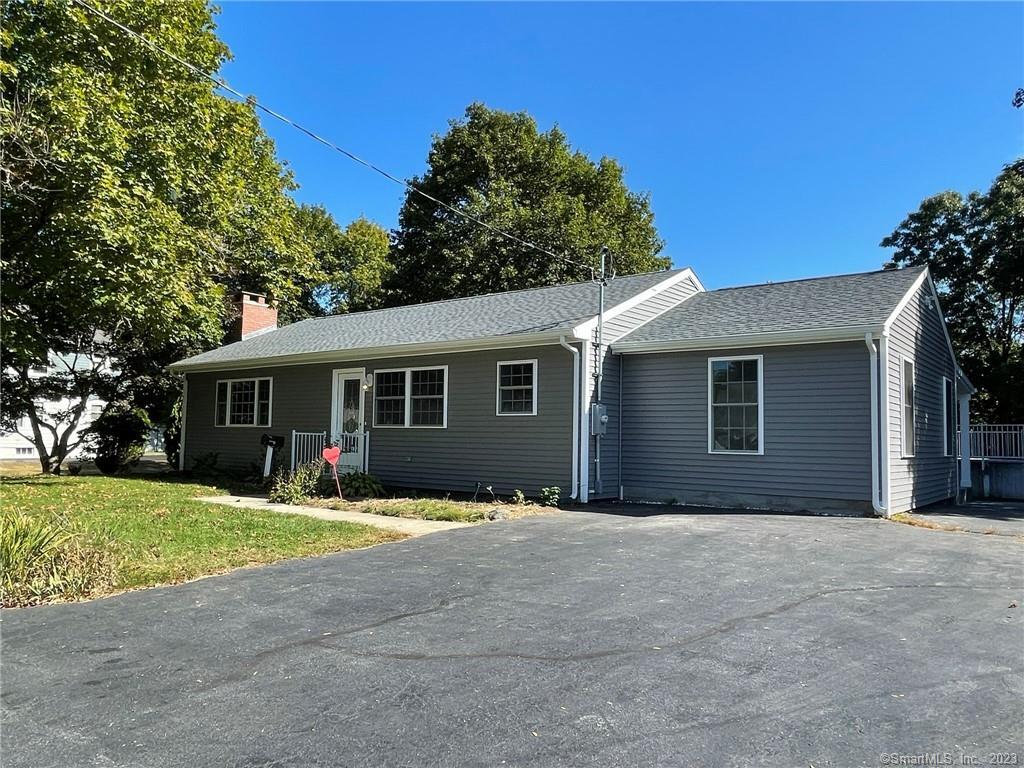 a view of a house with a yard and large trees