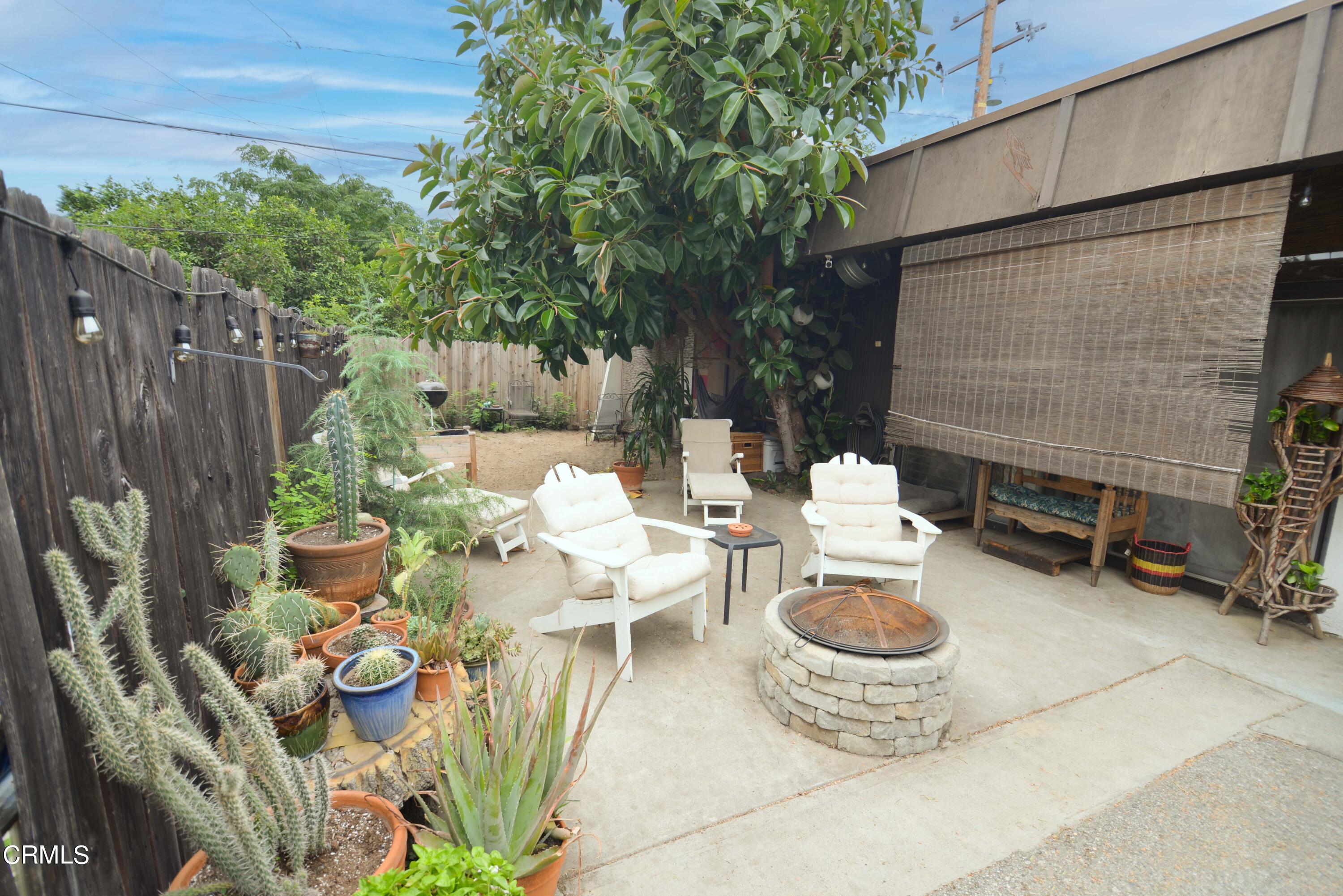 a view of a patio with chairs and potted plants