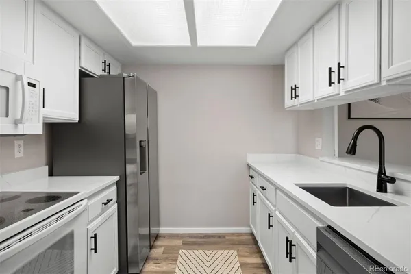 a kitchen with white cabinets and stainless steel appliances