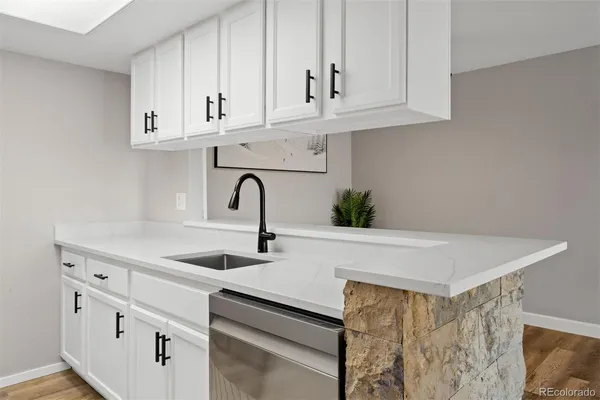 a kitchen with stainless steel appliances granite countertop white cabinets and a sink