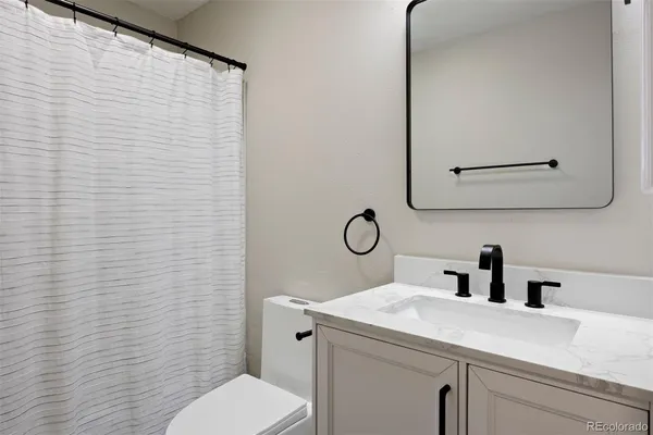 a bathroom with a sink a toilet and mirror