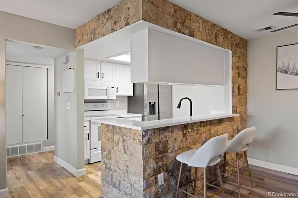 a kitchen with stainless steel appliances granite countertop a table and chairs in it