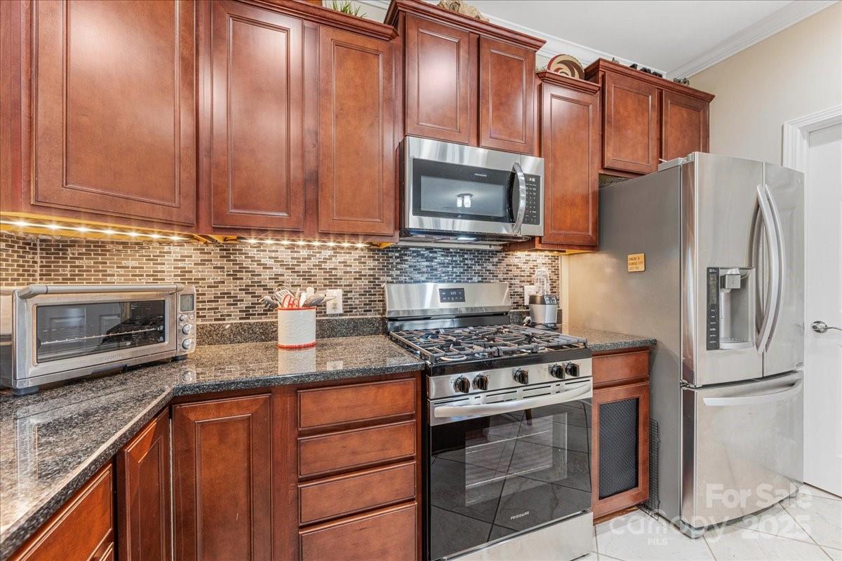 2056 Kennedy Drive Fort Mill, SC 29707 - Photo 18 of 45 a kitchen with granite countertop a stove top oven microwave and refrigerator