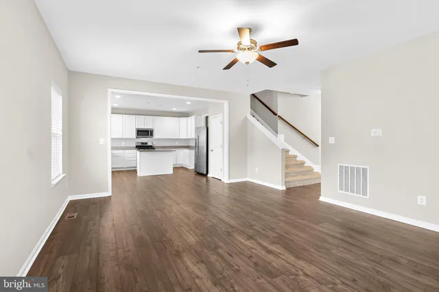 a view of empty room with wooden floor and window