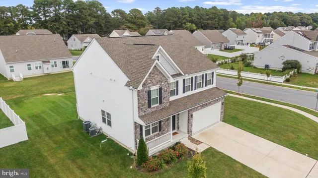 an aerial view of residential house with outdoor space and trees around