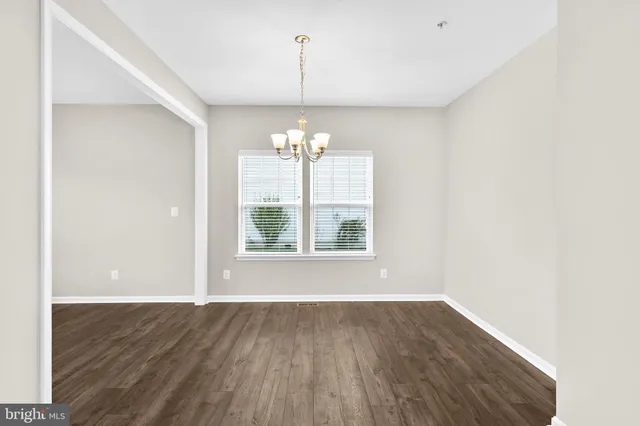 a view of a room with wooden floor chandelier and window