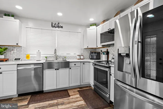 a kitchen with stainless steel appliances a stove sink and refrigerator