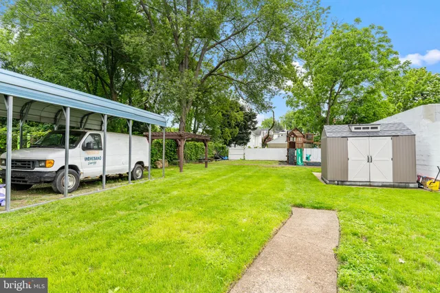 a view of a house with backyard and a tree