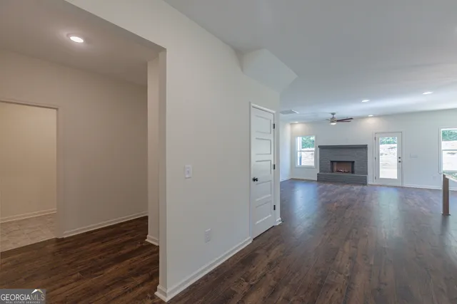 an empty room with wooden floor and fireplace