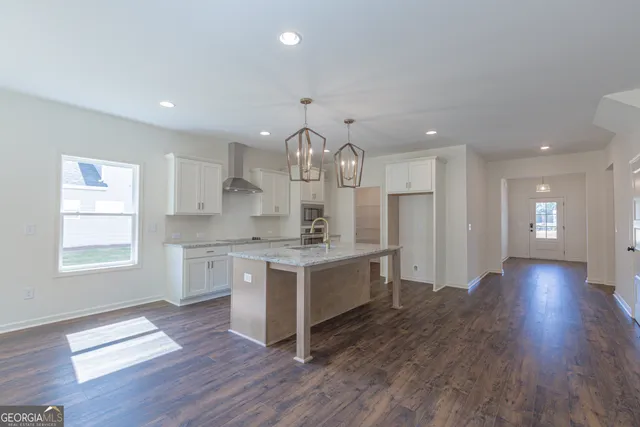 a large kitchen with granite countertop a large center island a sink stainless steel appliances and cabinets