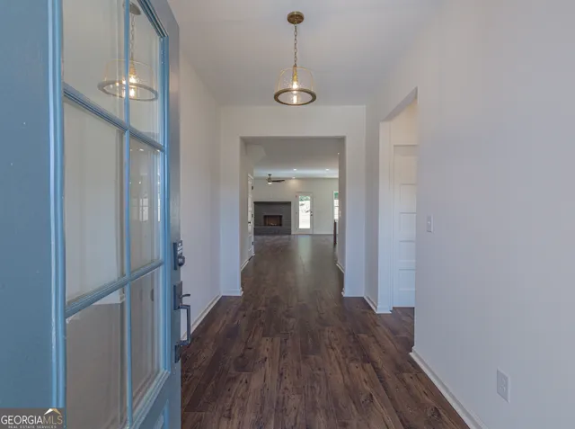 a view of a hallway with wooden floor and staircase