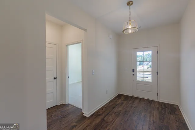 a view of empty room with wooden floor and window