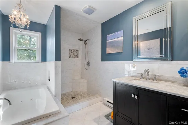 a bathroom with a bath tub sink mirror and a shower