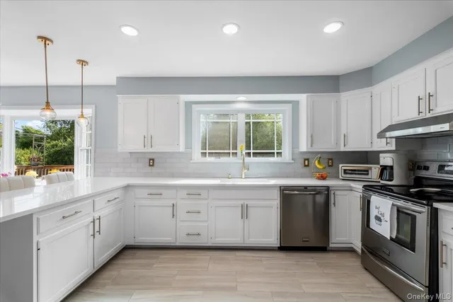 a kitchen with stainless steel appliances granite countertop a sink a stove and cabinets