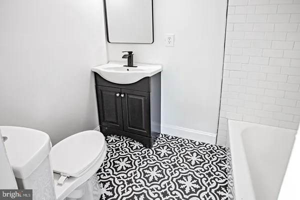 a bathroom with a sink a toilet a mirror and shower