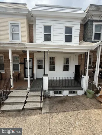 a view of a house with a small yard and wooden floor and fence