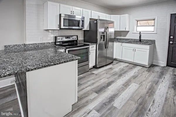 a kitchen with stainless steel appliances granite countertop a refrigerator stove a sink and dishwasher