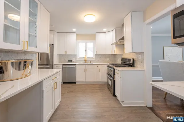 a kitchen with a sink white cabinets and white appliances