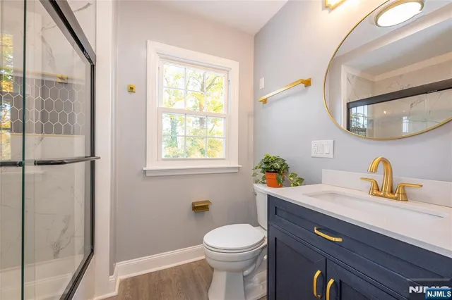 a bathroom with a granite countertop toilet sink and mirror