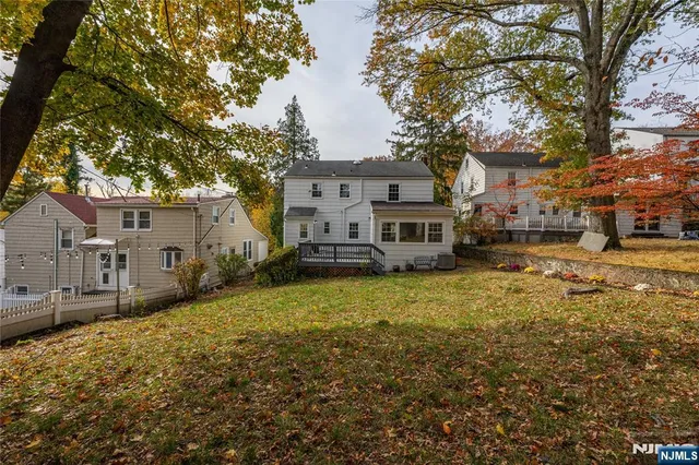 a view of a house with a large tree in front of it