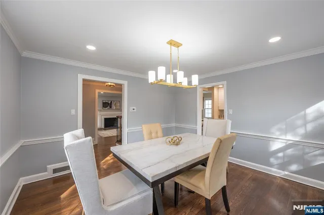 a view of a dining room with furniture a chandelier and wooden floor