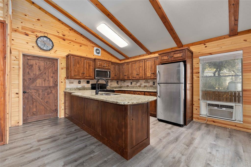 4010 Seneca Circle May, TX 76857 - Photo 18 of 30 a kitchen with stainless steel appliances granite countertop a refrigerator a stove and a wooden floors