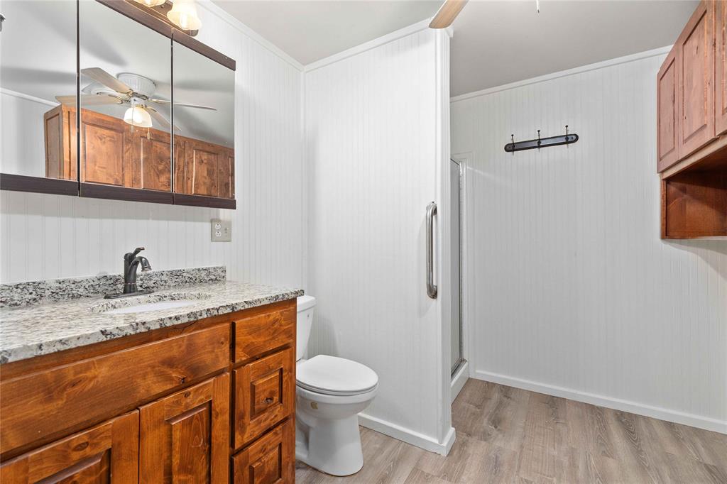 4010 Seneca Circle May, TX 76857 - Photo 26 of 30 a bathroom with a granite countertop sink a toilet and a mirror