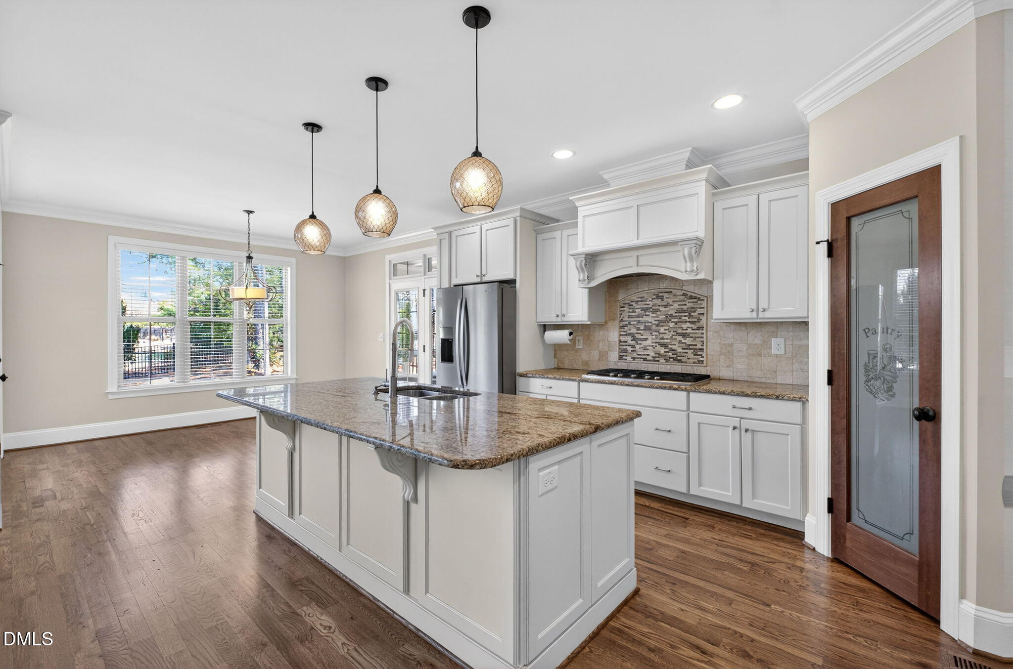 2700 Eastern Star Circle Rolesville, NC 27571 - Photo 8 of 75 a kitchen with kitchen island granite countertop a stove a sink a center island a refrigerator and a wooden floor