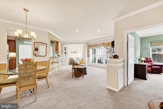 a living room with furniture a chandelier and a view of kitchen