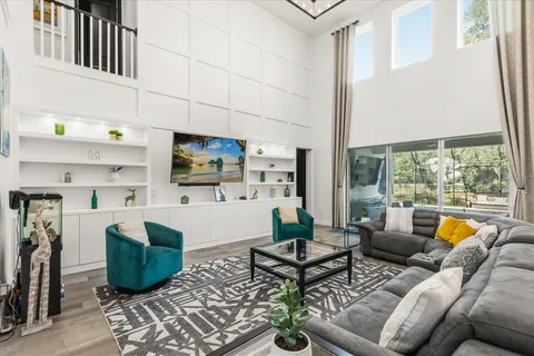 a living room with furniture a rug and a floor to ceiling window