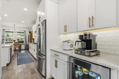 a kitchen with stainless steel appliances kitchen island a table chairs in it and wooden floors