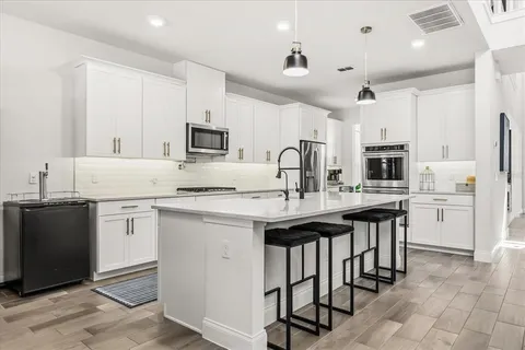 a kitchen with stainless steel appliances a sink stove and cabinets