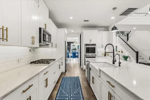 a kitchen with kitchen island granite countertop a sink appliances and cabinets