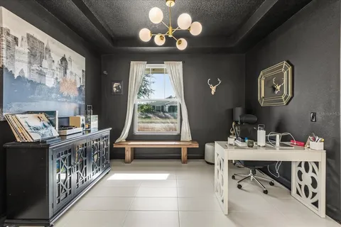a dining room with wooden floor and a chandelier