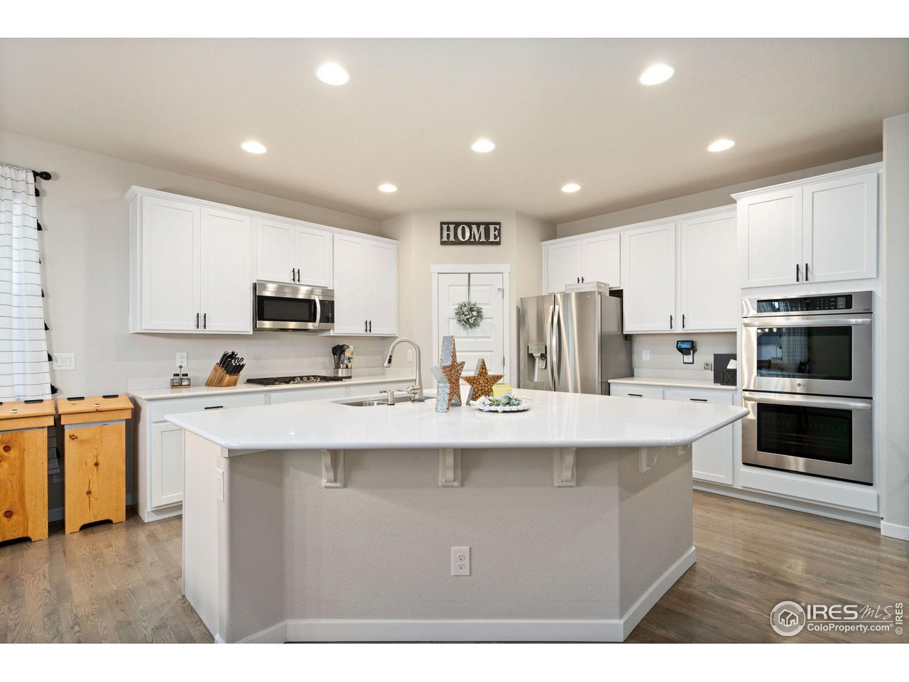 2167 First Light Court Windsor, CO 80550 - Photo 10 of 40 a kitchen with stainless steel appliances a stove sink microwave and cabinets