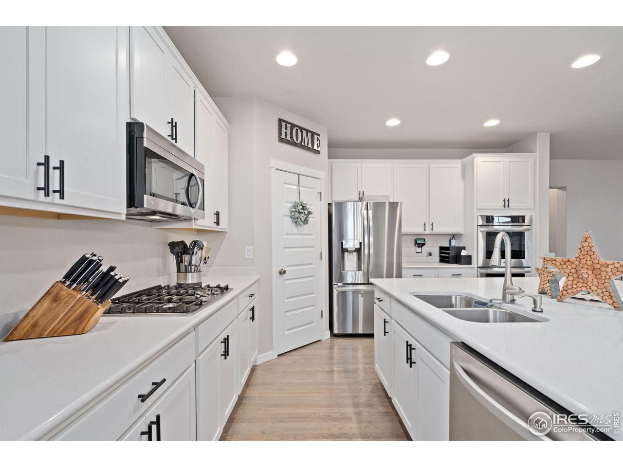 2167 First Light Court Windsor, CO 80550 - Photo 11 of 40 a kitchen with stainless steel appliances granite countertop a sink stove and refrigerator