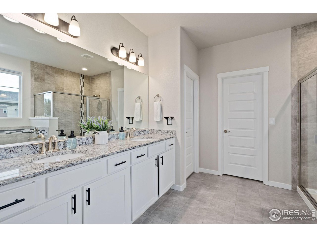 2167 First Light Court Windsor, CO 80550 - Photo 16 of 40 a bathroom with a granite countertop sink and a mirror