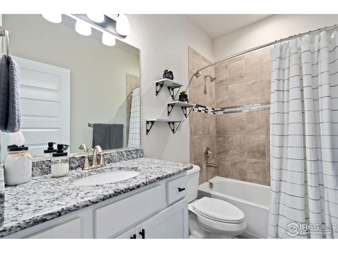 2167 First Light Court Windsor, CO 80550 - Photo 21 of 40 a bathroom with a granite countertop sink toilet and shower
