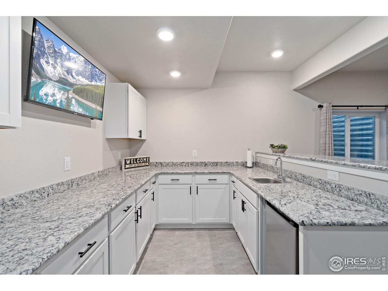 2167 First Light Court Windsor, CO 80550 - Photo 28 of 40 a kitchen with granite countertop a sink and cabinets