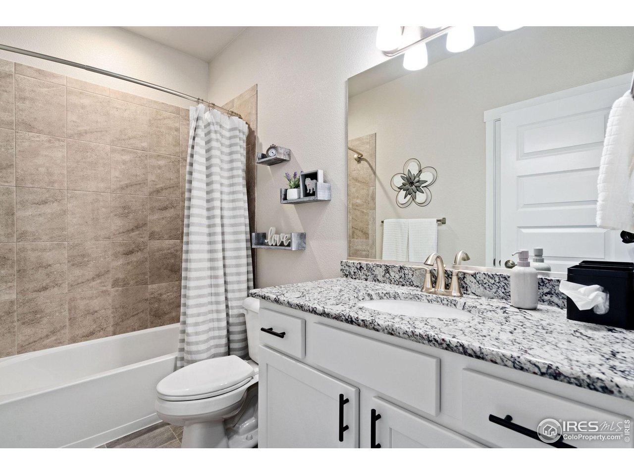 2167 First Light Court Windsor, CO 80550 - Photo 30 of 40 a bathroom with a granite countertop sink mirror vanity and toilet