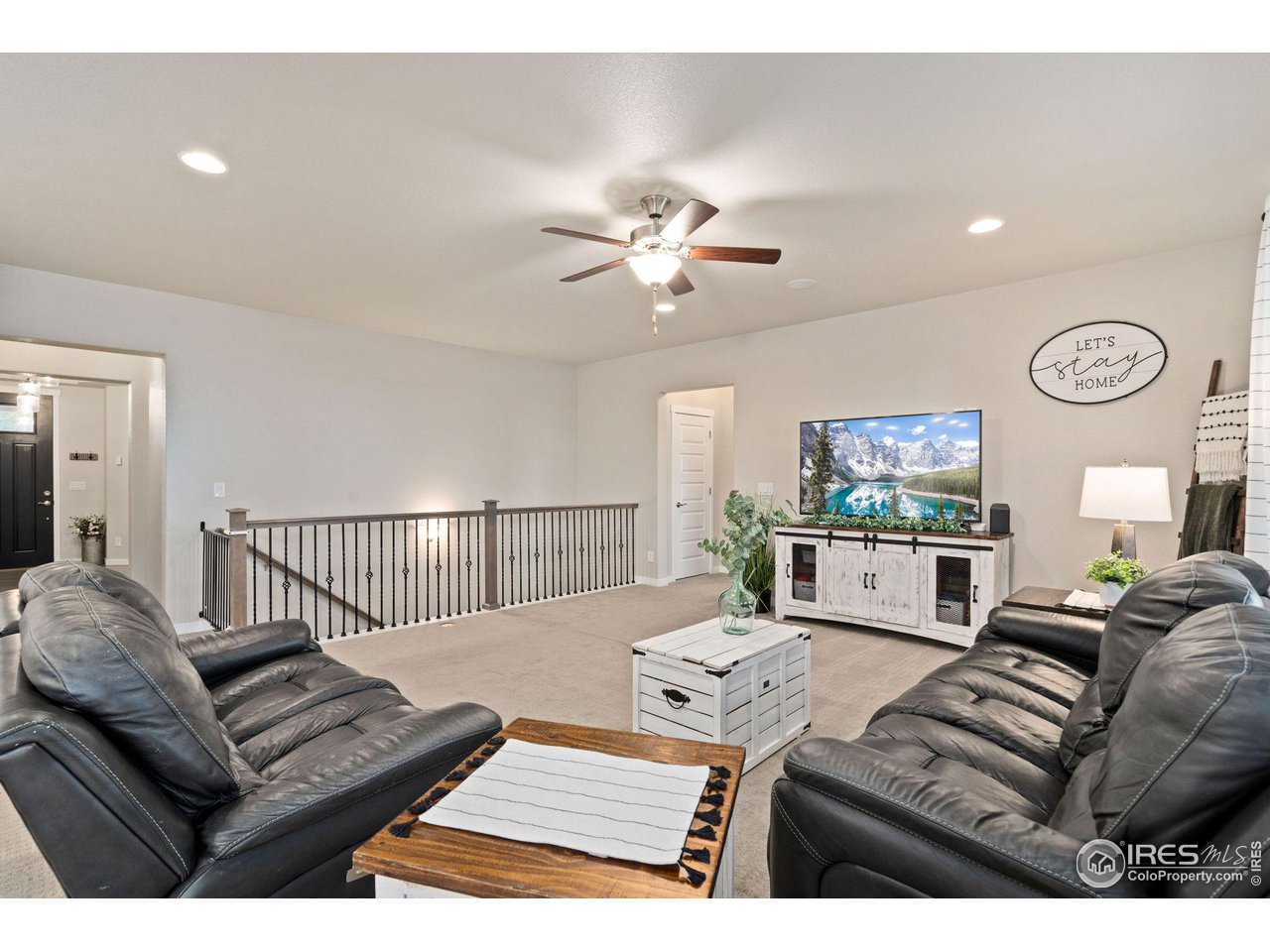 2167 First Light Court Windsor, CO 80550 - Photo 8 of 40 a living room with furniture a chandelier and a window