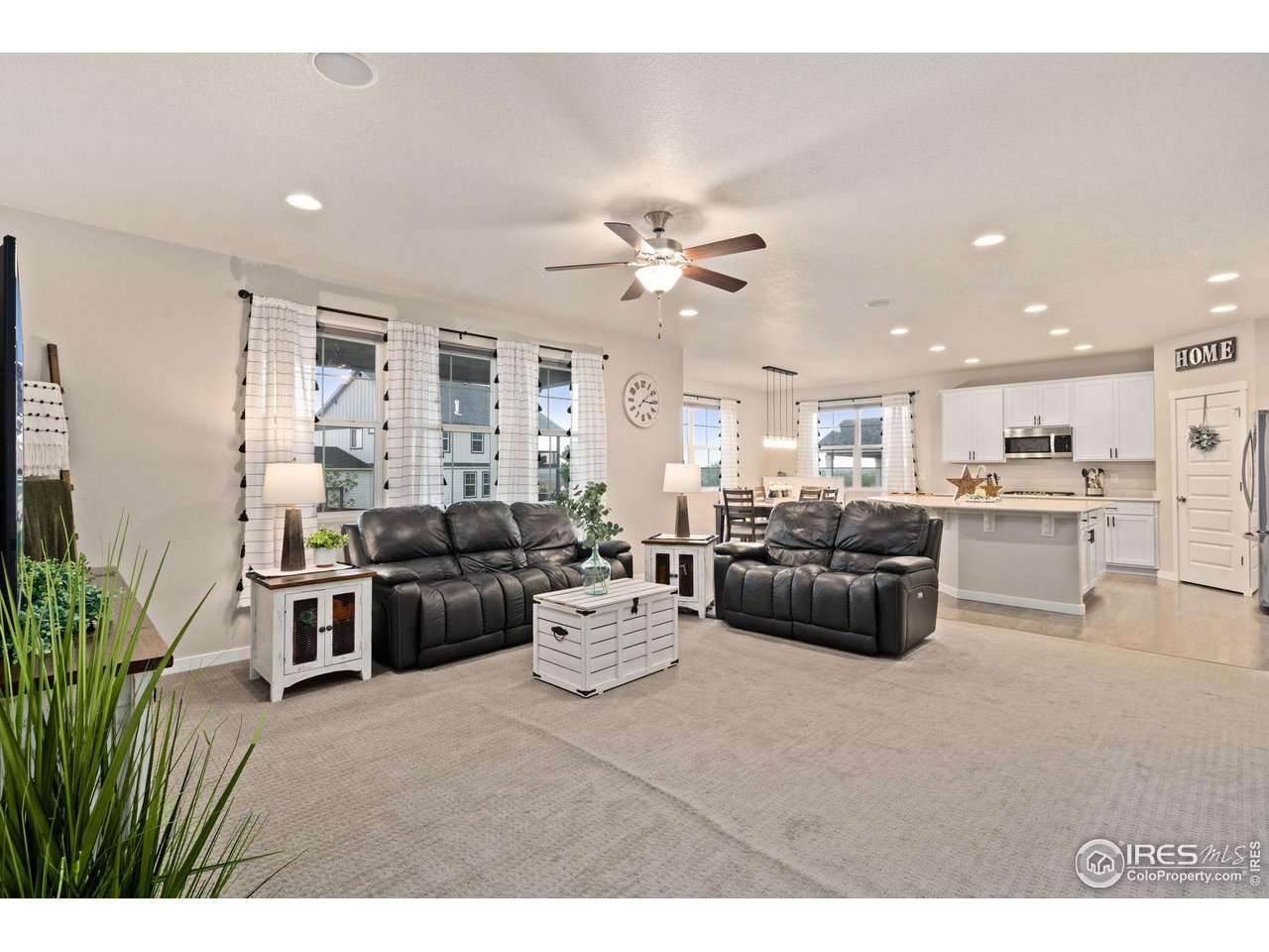 2167 First Light Court Windsor, CO 80550 - Photo 40 of 40 a living room with furniture kitchen view and a chandelier