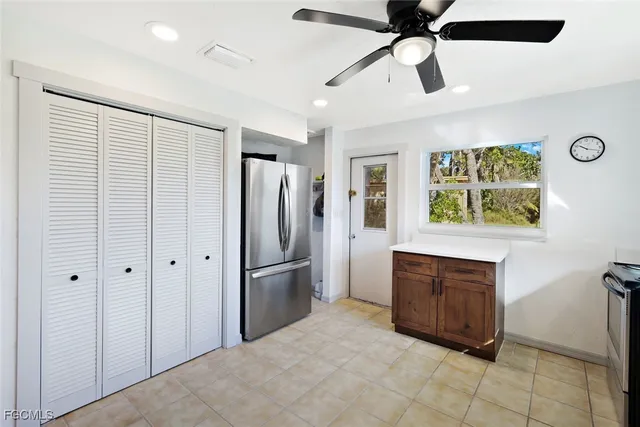 a kitchen with stainless steel appliances kitchen island granite countertop a refrigerator and a stove top oven