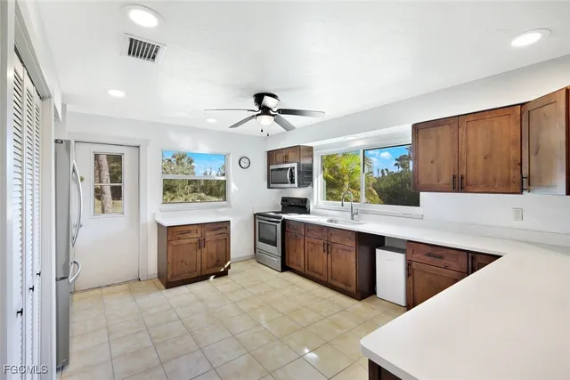a large kitchen with kitchen island a sink stainless steel appliances and window