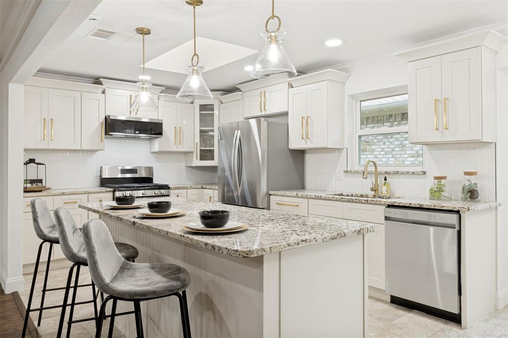 9552 Timberleaf Drive Dallas, TX 75243 - Photo 13 of 32 a kitchen with stainless steel appliances granite countertop a stove and white cabinets